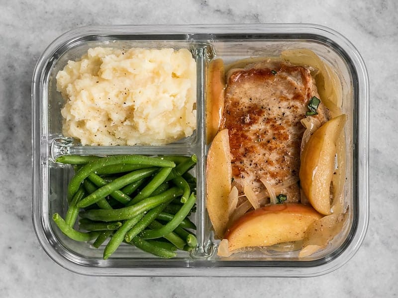 This Apple Spice Pork Chop meal prep is packed with tender and juicy pork chops, creamy mashed potatoes, and bright green beans. BudgetBytes.com One Apple Spice Pork Chop meal prep container