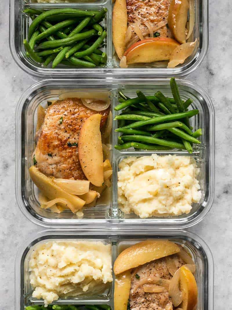 This Apple Spice Pork Chop meal prep is packed with tender and juicy pork chops, creamy mashed potatoes, and bright green beans. BudgetBytes.com Three Apple Spice Pork Chop meal prep containers in a row