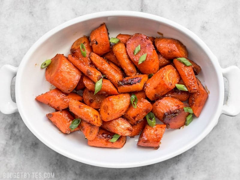 These Maple Miso Roasted Carrots are sweet, savory, and rich, and make a great side dish to any Asian inspired meal. BudgetBytes.com Maple Miso Roasted Carrots in a serving dish with green onions