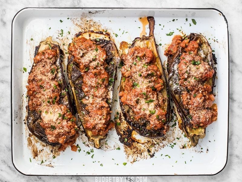 Roasted Eggplant with Meat Sauce is an elegant low carb main dish that will leave you satisfied. Pair with a simple green salad for a complete meal. BudgetBytes.com Four Roasted Eggplant with Meat Sauce lined up on a baking sheet