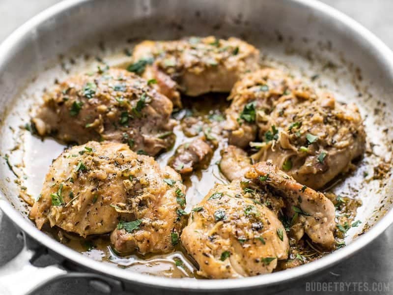 A quick and buttery herb pan sauce makes these Herb Butter Chicken Thighs a decadent, yet easy weeknight recipe, using only simple pantry staples! A close up of the herb butter chicken thighs in the skillet just after cooking.