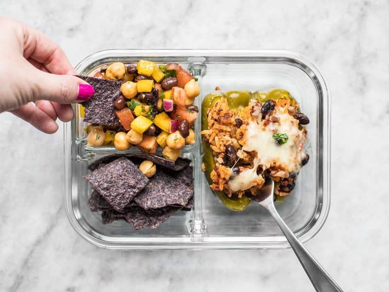 Stuffed bell peppers make the perfect meal prep item and are paired with Cowboy Caviar and chips for dipping in this Stuffed Bell Pepper Meal Prep. BudgetBytes.com A chip being dipped into the Cowboy Caviar in the meal prep container