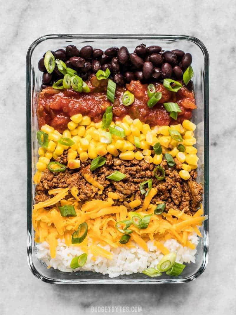 The Easiest Burrito Bowl Meal Prep that you can put together in about 30 minutes with minimal cooking, chopping, and nothing to pack on the side. Lunch can be easy and tasty! BudgetBytes.com Close up of one Burrito Bowl Meal Prep container