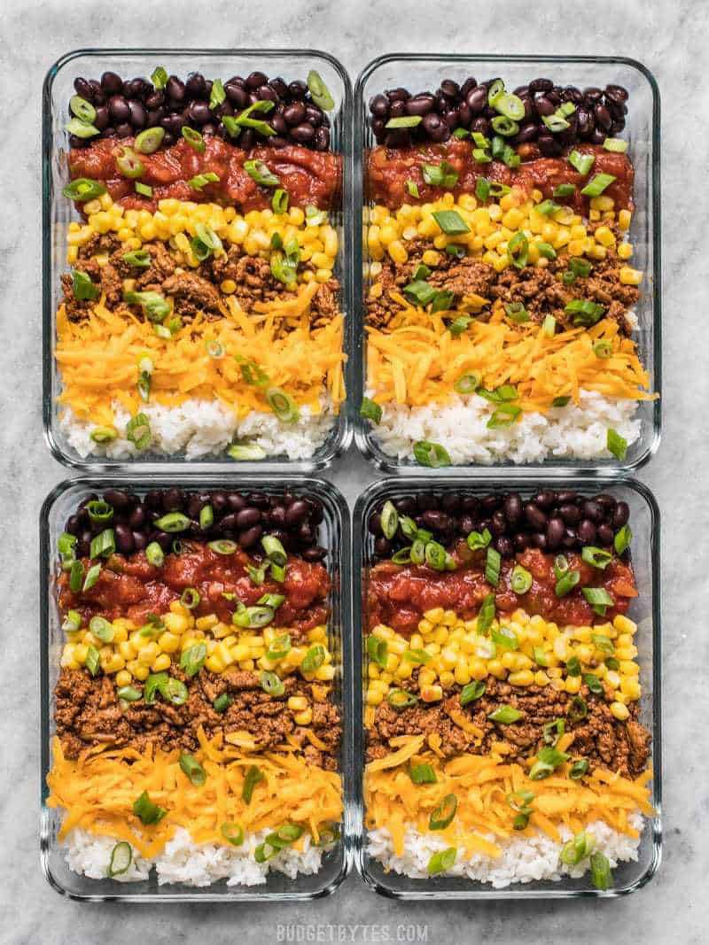 The Easiest Burrito Bowl Meal Prep that you can put together in about 30 minutes with minimal cooking, chopping, and nothing to pack on the side. Lunch can be easy and tasty! BudgetBytes.com Build Burrito Bowls in the meal prep containers