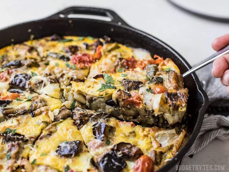 Ratatouille Frittata combines the rich and complex flavors of ratatouille with the ease of an egg frittata. Great for low carb breakfast or brunch! Budgetbytes.com One slice of the Ratatouille Frittata being lifted out of the skillet