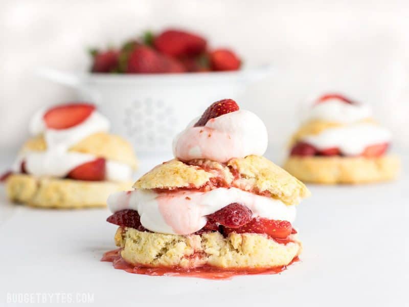 Strawberry Shortcake is a simple yet impressive dessert that requires nothing but some fresh fruit and a few pantry staples. BudgetBytes.com Three Strawberry Shortcakes with strawberry juice drizzled over top