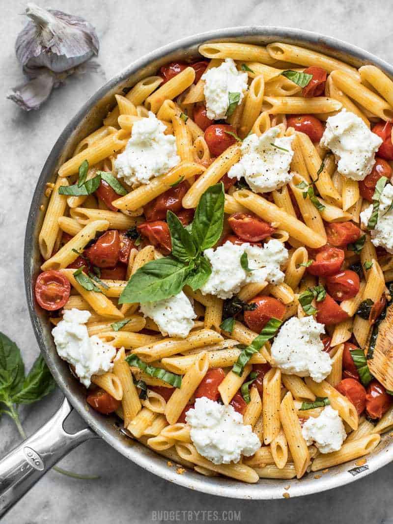 It only takes a few fresh ingredients make this Fresh Tomato Basil Pasta with Ricotta, the perfect light lunch or dinner for summer! BudgetBytes.com A skillet full of Fresh Tomato Basil Pasta with Ricotta. Fresh basil on top, garlic on the side.