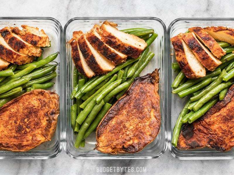 Smoky Chicken and Cinnamon Roasted Sweet Potato Meal Prep is an easy, delicious, filling, and healthy daily lunch or dinner. BudgetBytes.com Three glass meal prep containers in a row with Smoky Chicken and Cinnamon Roasted Sweet Potatoes