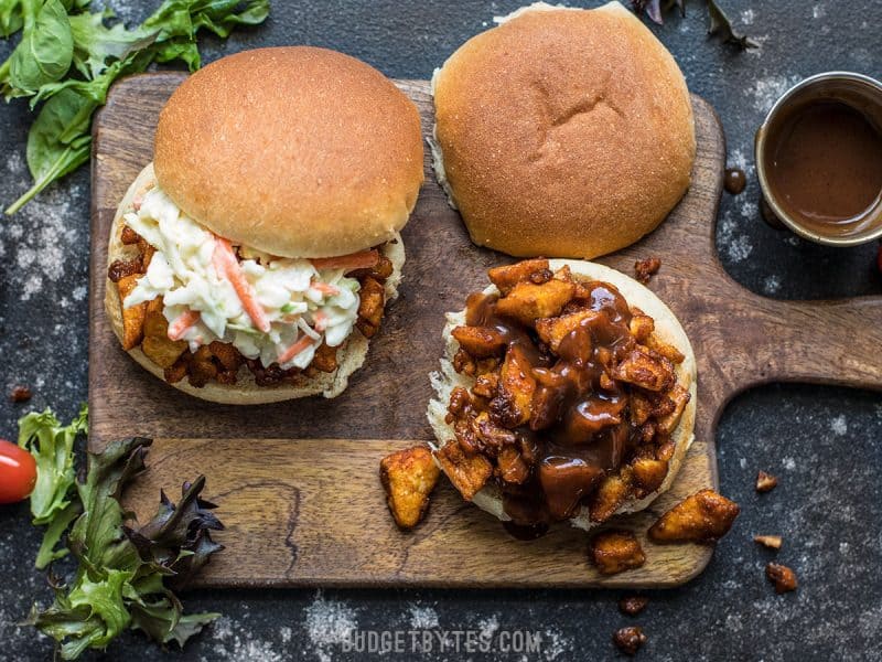 BBQ Tofu Sliders are an easy and inexpensive alternative to pulled meat sandwiches. With a simple ingredient list, this is a tofu dish anyone can master! Overhead view of two BBQ Tofu Sliders one with with the top bun off