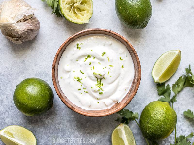 This tangy, creamy, fresh, and garlicky Lime Crema is the key to taking your tacos, nachos, salads, and more to the next level. Budgetbytes.com Finished Lime Crema with lime zest on top
