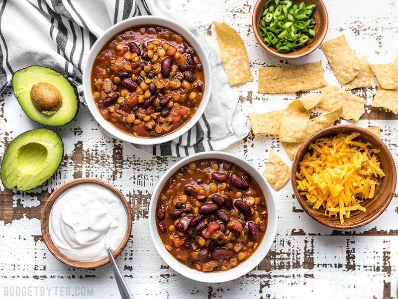 This Slow Cooker Vegetarian Lentil Chili makes a huge batch, is packed with flavor and nutrients, and can be made for only about 5 dollars! Budgetbytes.com Slow Cooker Vegetarian Lentil Chili ready to top