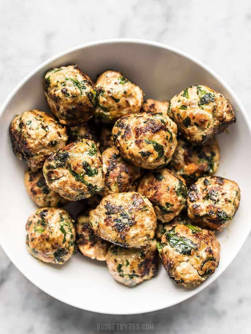 Spinach and Feta Turkey Meatballs are an easy way to add flavor and protein to your meal using inexpensive ground turkey. Perfect for meal prep! Budgetbytes.com Cooked Spinach and Feta Turkey Meatballs in a bowl.