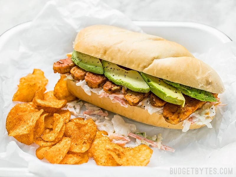 Spicy hot buffalo sauce, creamy avocado, and a rich and tangy ranch slaw makes these Buffalo Tempeh Sandwiches fiery perfection! Budgetbytes.com Buffalo Tempeh Sandwich with chips