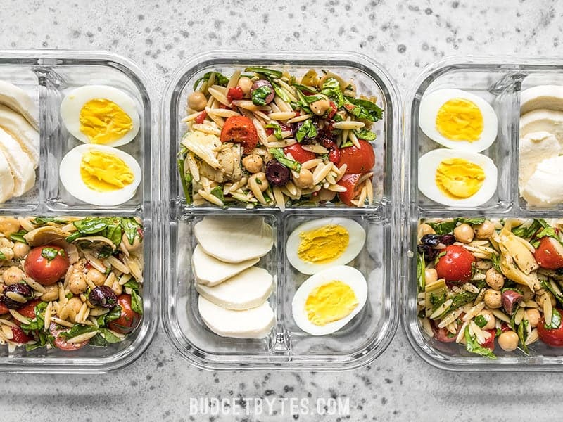 Three Orzo Salad Meal Prep Lunch Boxes with Egg and Mozzarella - Budgetbytes.com Line up of Orzo Salad Meal Prep Lunch Boxes