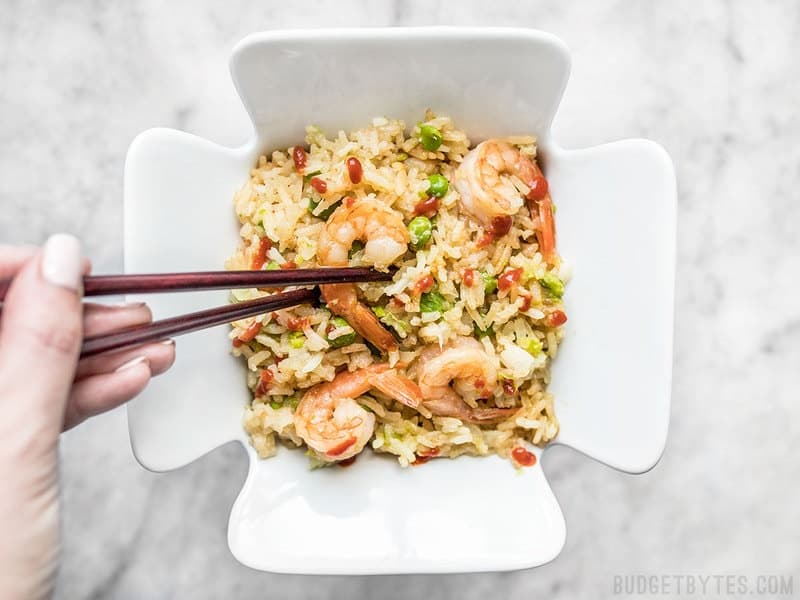 By adding a few extra ingredients to your rice cooker, you can cook an entire meal at once. This Teriyaki Shrimp and Rice is an easy and healthy alternative to take out. Budgetbytes.com Someone eating the Teriyaki Shrimp and Rice out of a take out container using chopsticks