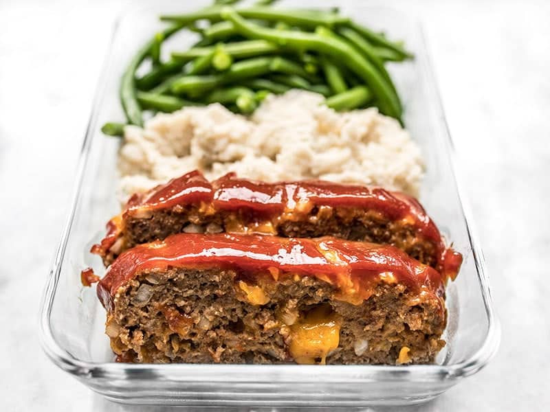 This Cheeseburger Meatloaf Meal Prep is an easy American classic meal that you'll look forward to each day. Toss the TV dinners and make your own! Budgetbytes.com Front view of Cheddar Cheeseburger Meal Prep with melty cheese