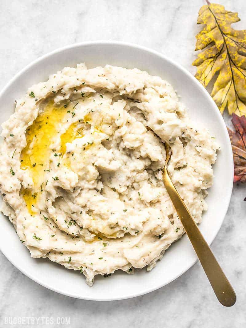Fluffy as a cloud and with a rich buttery finish, these Garlic Herb Mashed Potatoes will be the star of any weeknight dinner or holiday meal! Budgetbytes.com A big bowl of super fluffy Garlic Herb Mashed Potatoes with melted butter.