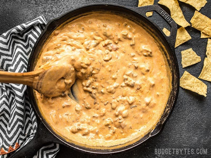 Once all the cheese has melted into the dip, turn the heat off. Garnish with sliced green onion and serve! Thick Spicy Chorizo Cheese Dip being stirred in the skillet.