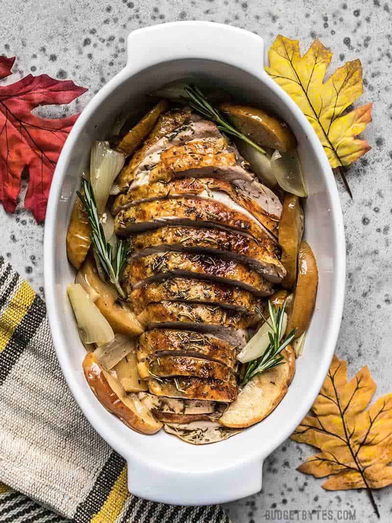 This easy herb-infused Cider Roasted Turkey Breast is the perfect answer to smaller Thanksgiving gatherings or those who are new to cooking. Budgetbytes.com Cider Roasted Turkey Breast sliced and ready to serve with roasted apples and onions.