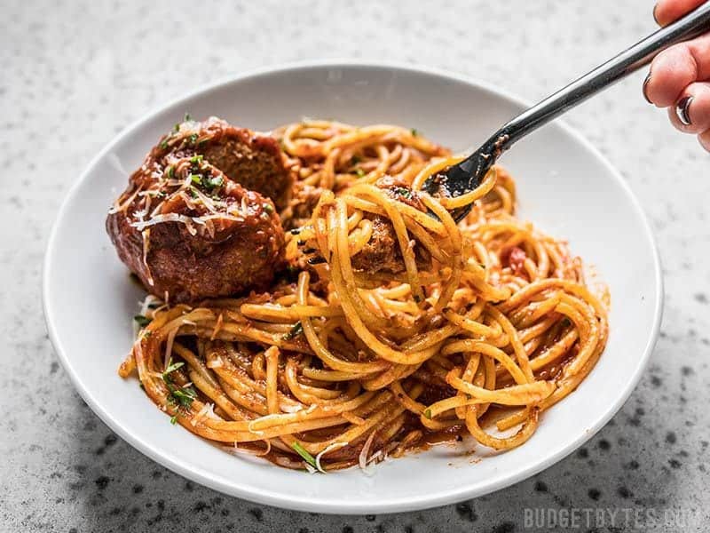 As easy as 1-2-3, these Giant Slow Cooker Meatballs are a fun, easy, and effortless answer to weeknight dinner. Budgetbytes.com A fork twirled with spaghetti and marinara on a plate with a Giant Slow Cooker Meatball