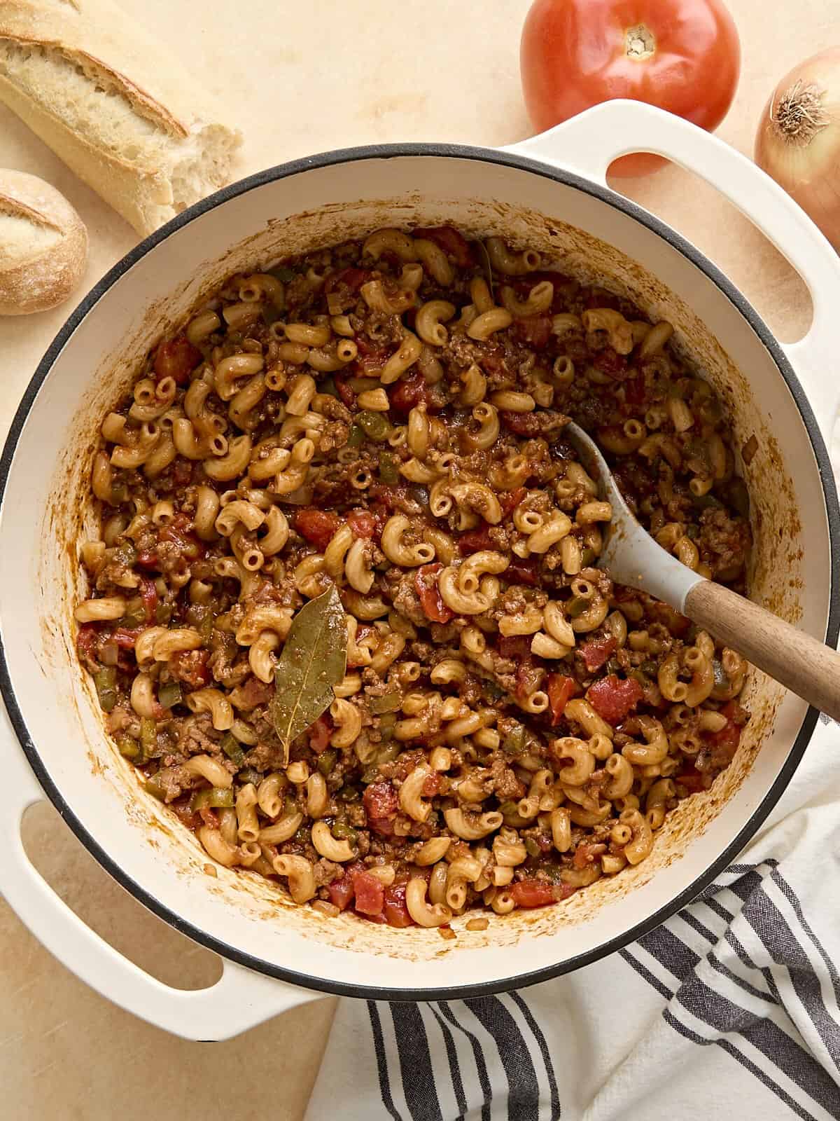 Overhead view of a pot of homemade American goulash with a wooden spoon.