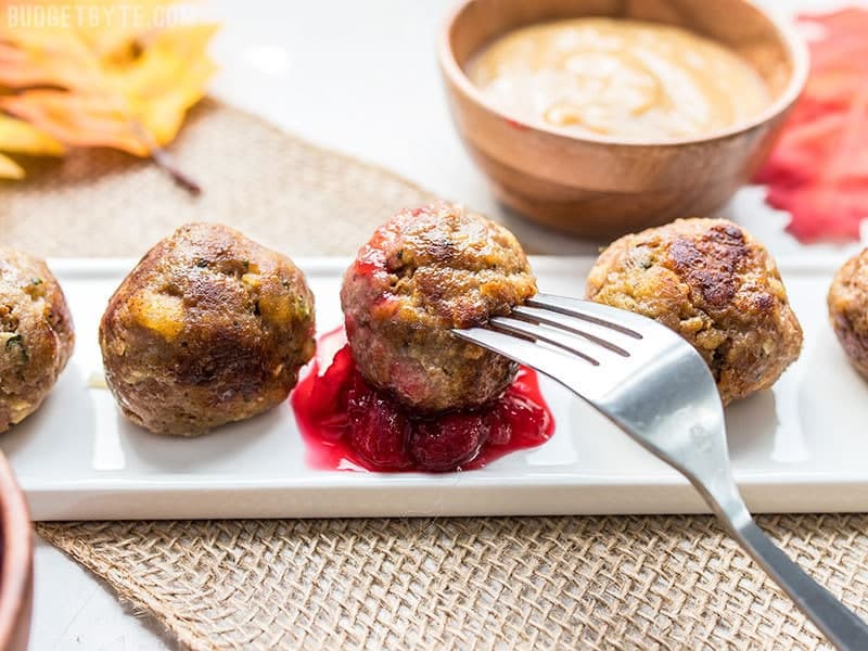 Turkey and Stuffing Meatballs make an easy and delicious addition to your Thanksgiving or Friendsgiving spread. Serve as an appetizer or main dish! Budgetbytes.com Turkey and Stuffing Meatballs served as appetizers and dipped in cranberry sauce.