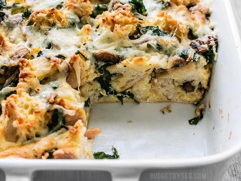 This Kale Swiss and Mushroom Strata is a filling and savory dish perfect for breakfast, brunch, or brinner! Prep the night before and bake in the morning! Budgetbytes.com Cross-section of baked Kale Swiss and Mushroom Strata
