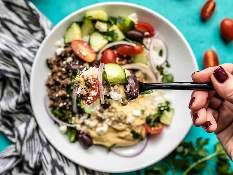 Just about any protein or vegetable can be added to these filling and tasty Mediterranean Hummus Bowls to make them your own and use up your leftovers! Budgetbytes.com A fork full of Mediterranean Hummus Bowls