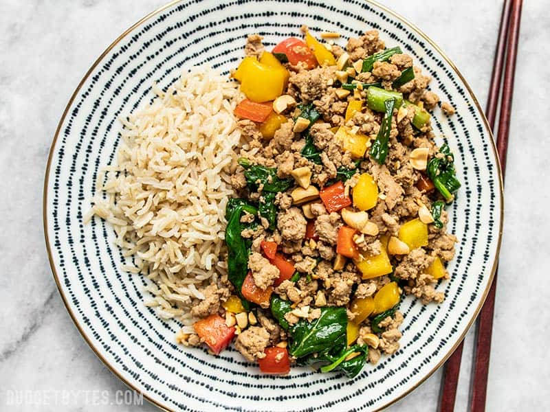 This super easy Ground Turkey Stir Fry is a delicious and versatile answer to busy weeknight dinners. Try the suggested variations to make it your own! Budgetbytes.com A patterned plate with Ground Turkey Stir Fry and Brown Rice, chopsticks on the side