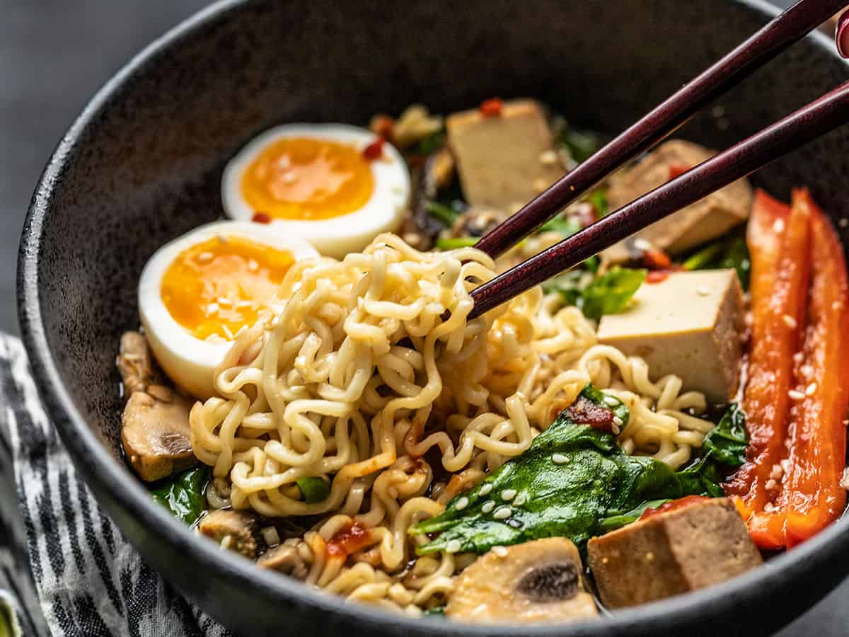 When all you have (or want) is one of those little cheap packets of noodles, here are 6 easy ways to upgrade instant ramen and make it a legit meal. BudgetBytes.com Close up side view of ramen noodles being picked up out of the bowl by chopsticks.