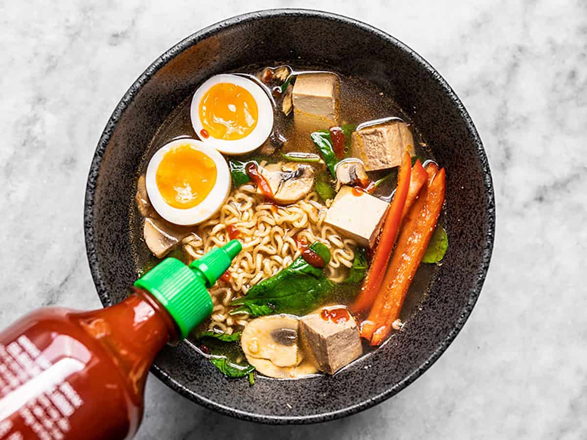 When all you have (or want) is one of those little cheap packets of noodles, here are 6 easy ways to upgrade instant ramen and make it a legit meal. Budetbytes.com Sriracha being drizzled over a bowl of instant ramen with other ingredients added.