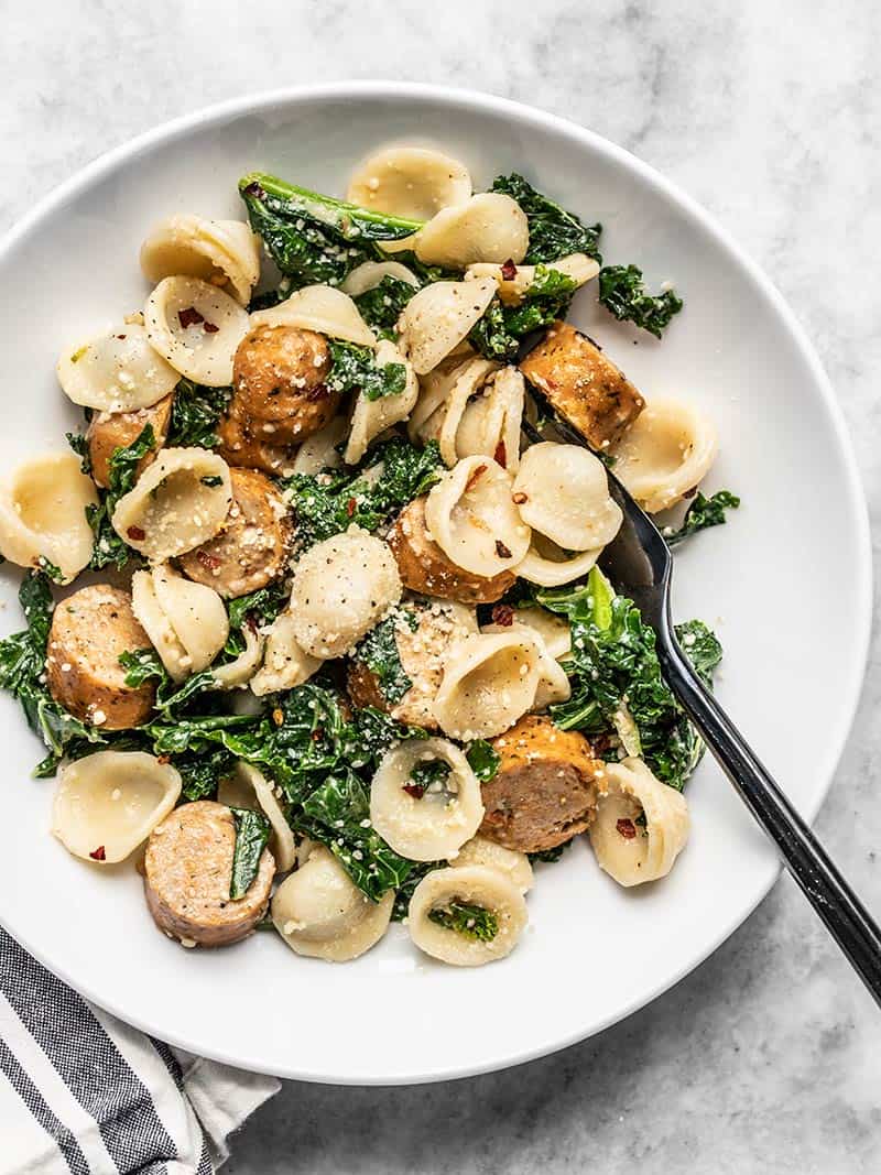 Overhead view of a shallow bowl full of Spicy Orecchiette with Chicken Sausage and Kale