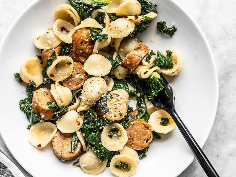 Spicy Orecchiette with Chicken Sausage and Kale is a fast, easy, and filling weeknight dinner that will always satisfy. Plus, leftovers reheat beautifully! Budgetbytes.com Overhead view of a shallow bowl full of Spicy Orecchiette with Chicken Sausage and Kale