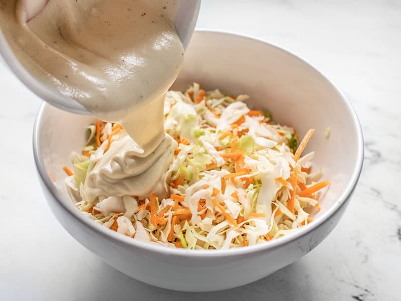 Combine shredded cabbage and dressing in bowl.