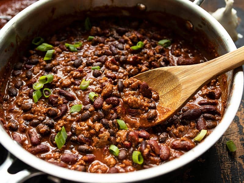 Serve these sweet, tangy, and savory BBQ Beef and Beans with rice and cheese for a simple and comforting weeknight dinner the whole family will love. Budgetbytes.com Close up of BBQ Beef and Beans in the skillet, topped with sliced green onion.