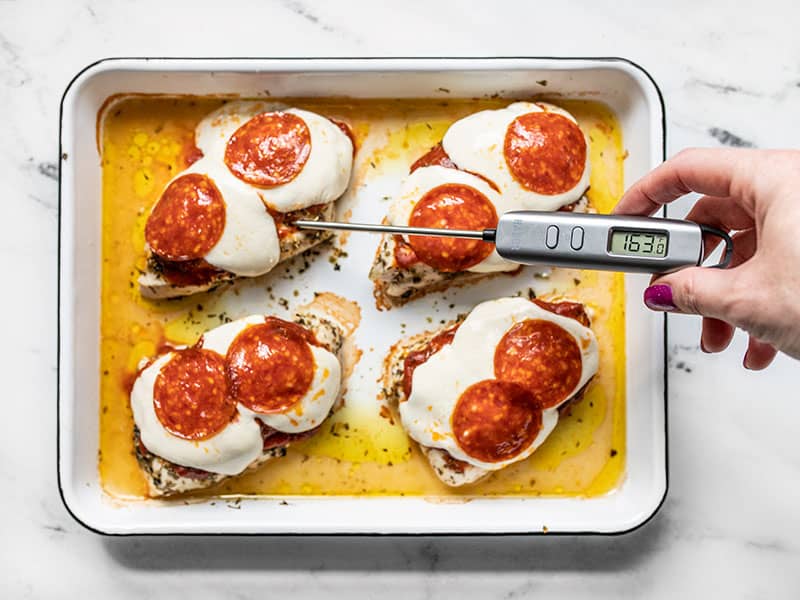 Baked Pizza Chicken with melted mozzarella and an instant read thermometer showing 163 degrees.