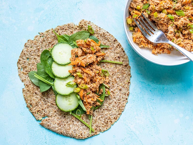 This Sweet and Spicy Tuna Salad is bold and flavorful, and has no mayonnaise! It's the perfect quick fix for summer months or your weekly meal prep. BudgetBytes.com Tortilla filled with spinach, cucumber slices, and Sweet and Spicy Tuna Salad