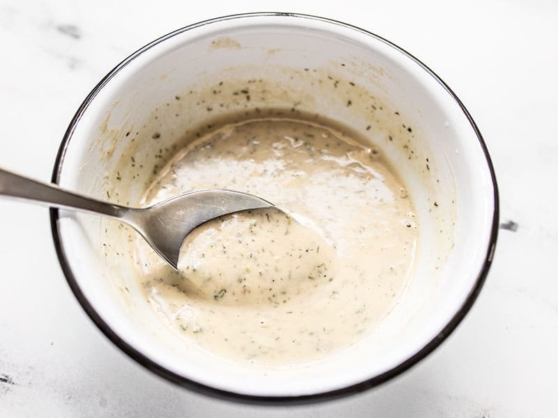 Pour this tangy Lemon Dill Tahini Dressing over roasted vegetables, grilled salmon or chicken, potato salad, or your favorite green salad. BudgetBytes.com A spoon dipping into a bowl of Lemon Dill Tahini Dressing