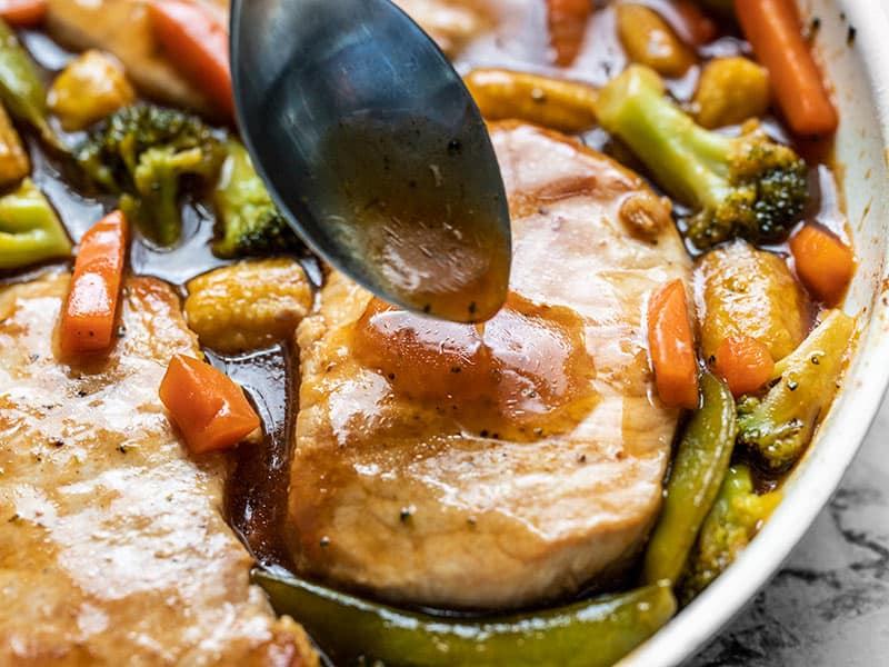 A few pantry staples are needed for these juicy Sweet and Sour Pork Chops with Vegetables, making them a quick and easy alternative to take-out. BudgetBytes.com Close up of Sweet and Sour Sauce being spooned over a pork chop in the skillet, surrounded by vegetables and sauce.