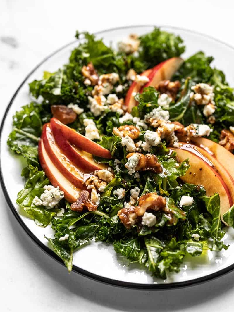 All the flavors of fall come together in this Autumn Kale and Apple Salad, with candied walnuts and a homemade balsamic vinaigrette. BudgetBytes.com Close up front view of an Autumn Kale and Apple Salad with Balsamic Vinaigrette
