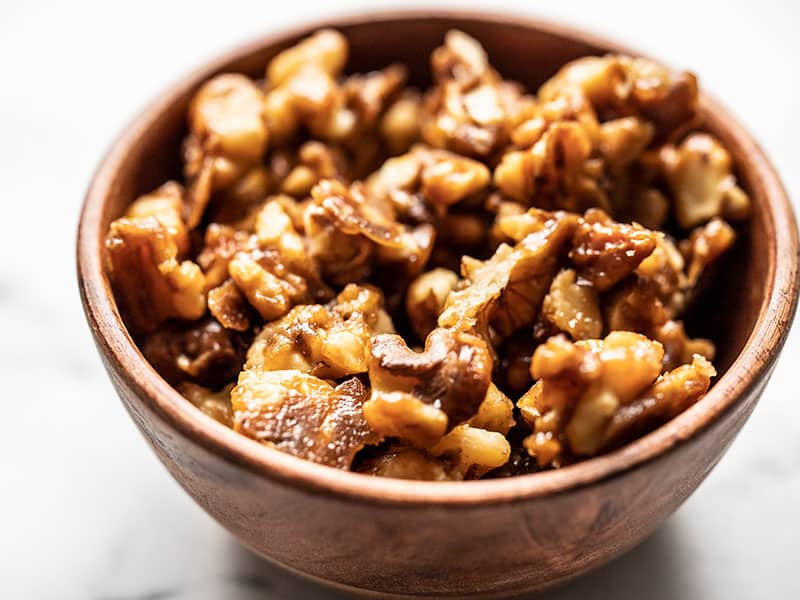 This small batch of crunchy candied walnuts is just the right amount of sweet, crunchy, and nutty topping for salads, desserts, oats, and more. BudgetBytes.com Close up of crunchy candied walnuts in a small wooden bowl