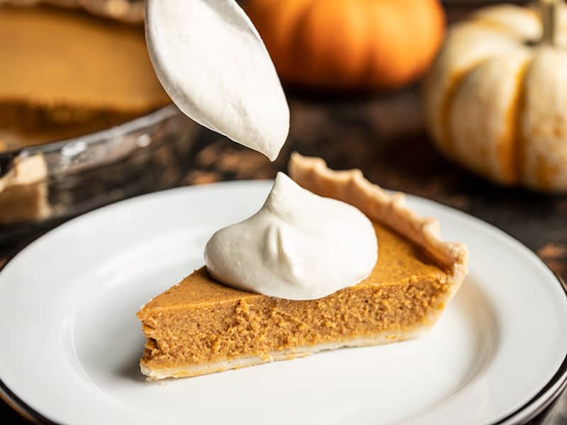 This Maple Brown Butter Pumpkin Pie is the perfect special touch for your Thanksgiving dinner, without adding a lot of extra work or unusual ingredients. BudgetBytes.com Whipped cream being scooped onto a slice of Maple Brown Butter Pumpkin Pie