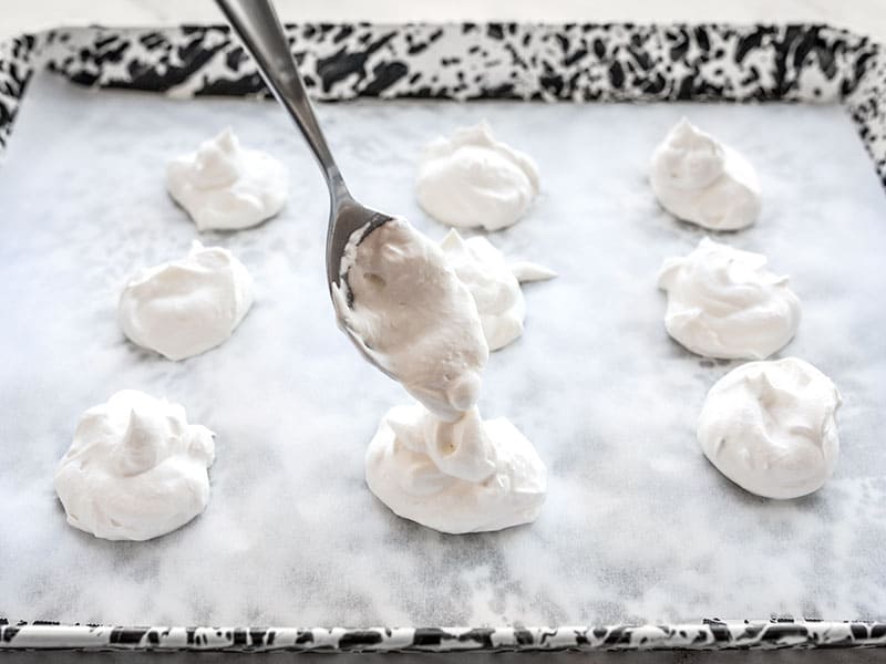 Whipped cream on lined baking sheet ready for freezing