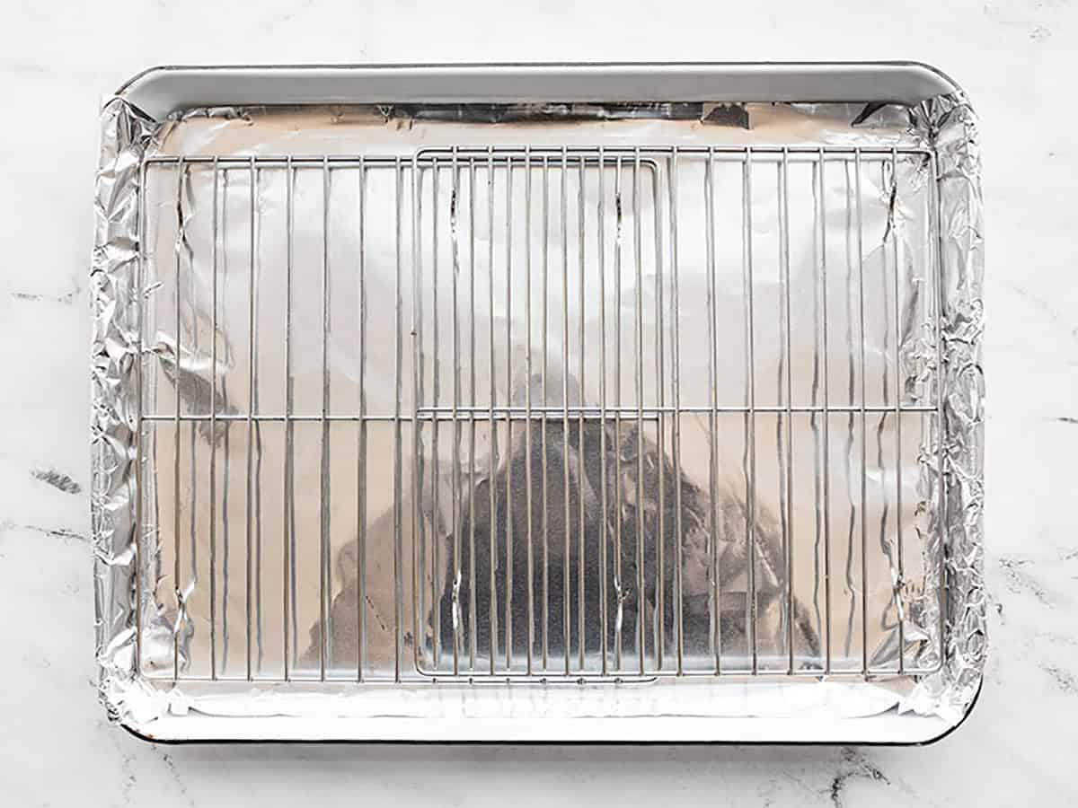 Baking sheet lined with foil and two wire racks sitting on top.