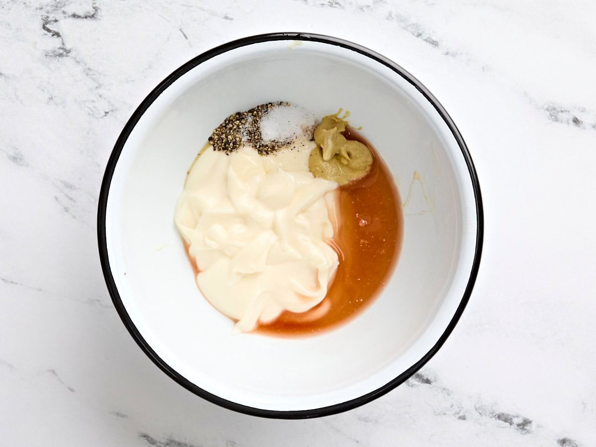 Mayonnaise, honey, Dijon, red wine vinegar, and seasonings in a bowl.