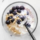 Cottage cheese, blueberries, sliced almonds, and honey in a glass meal prep container