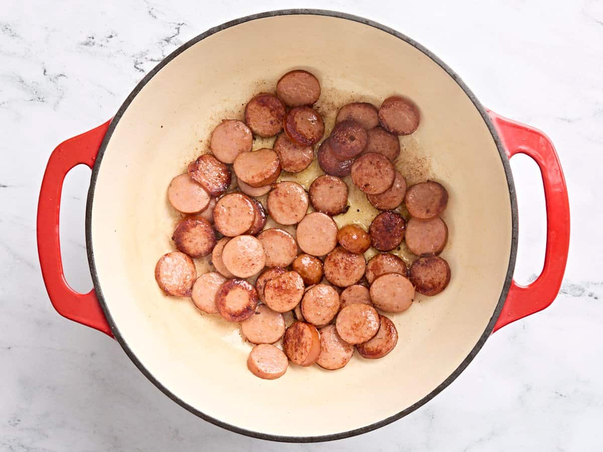 Sliced Andouille sausage in a skillet.
