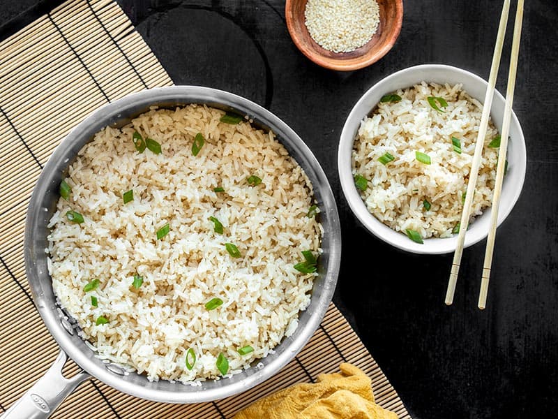 Adding just a few ingredients to your rice can really make your meal pop. Try this Simple Sesame Rice with any of your Southeast Asian inspired meals. BudgetBytes.com A pot full of sesame rice with a bowl of sesame rice on the side, both garnished with green onion