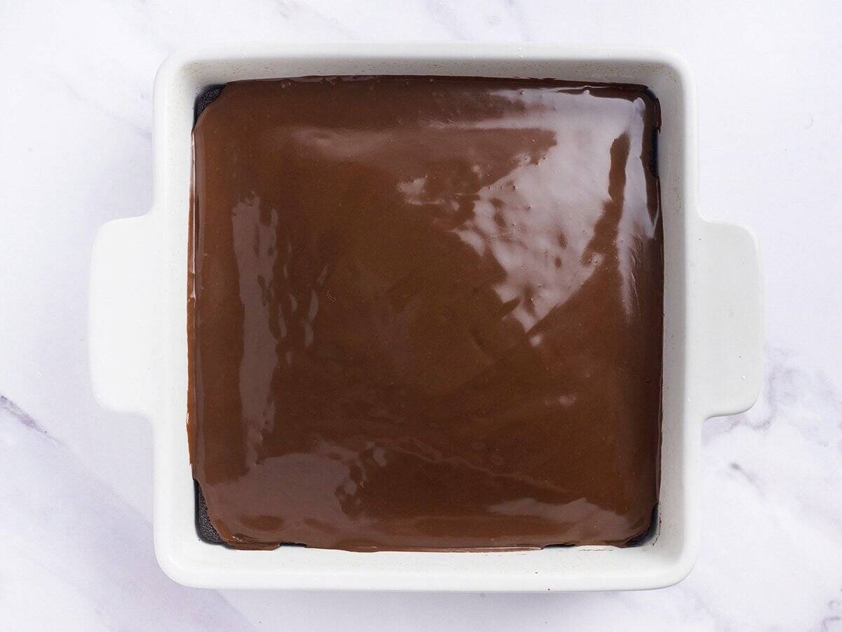 Overhead view of a iced chocolate depression cake in a baking dish.