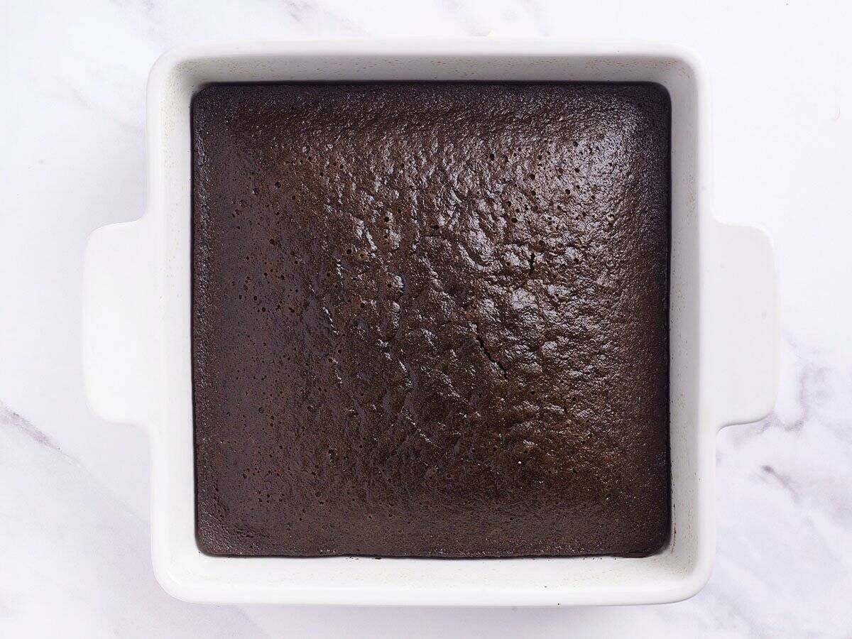 Overhead view of a freshly baked chocolate cake in a baking dish.